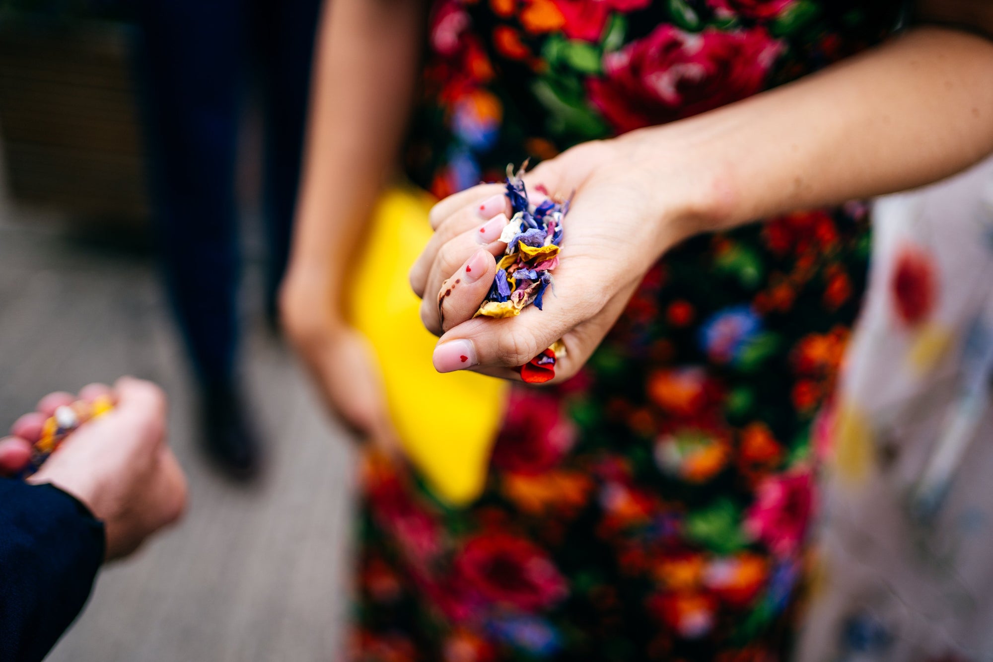 Close-up of hands holding colorful confetti with a blurred background