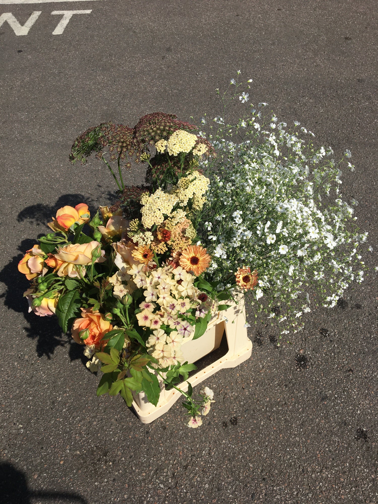 Bucket of flowers on a dark surface. Peach and white flowers