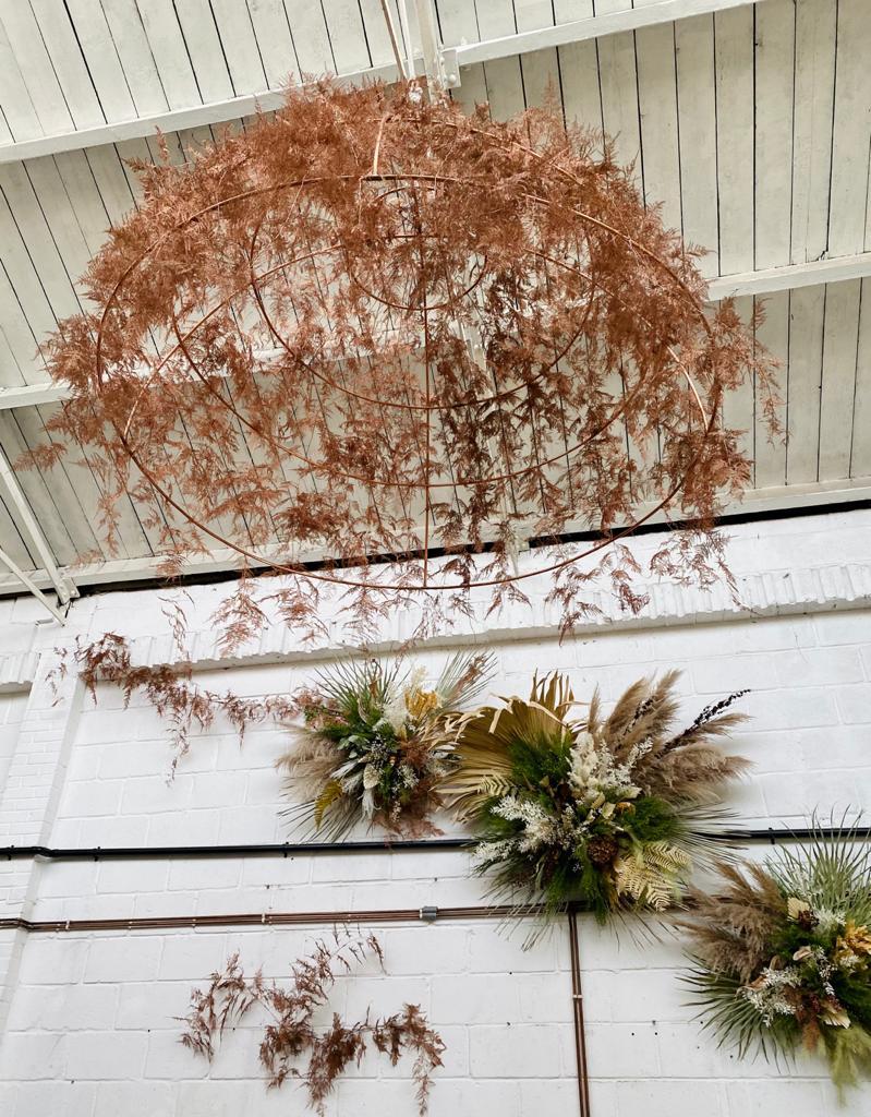 Decorative dried suspended installation and wall decor in copper and neutral tones for a gin bar. Copper colours echo copper piping along walls