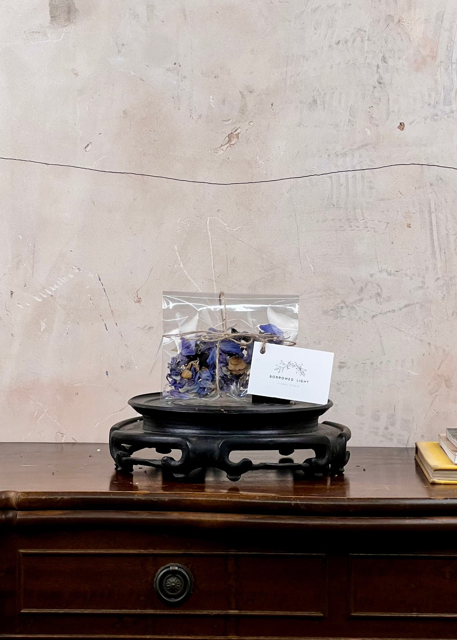 Packaged product on a wooden stand with a textured wall background