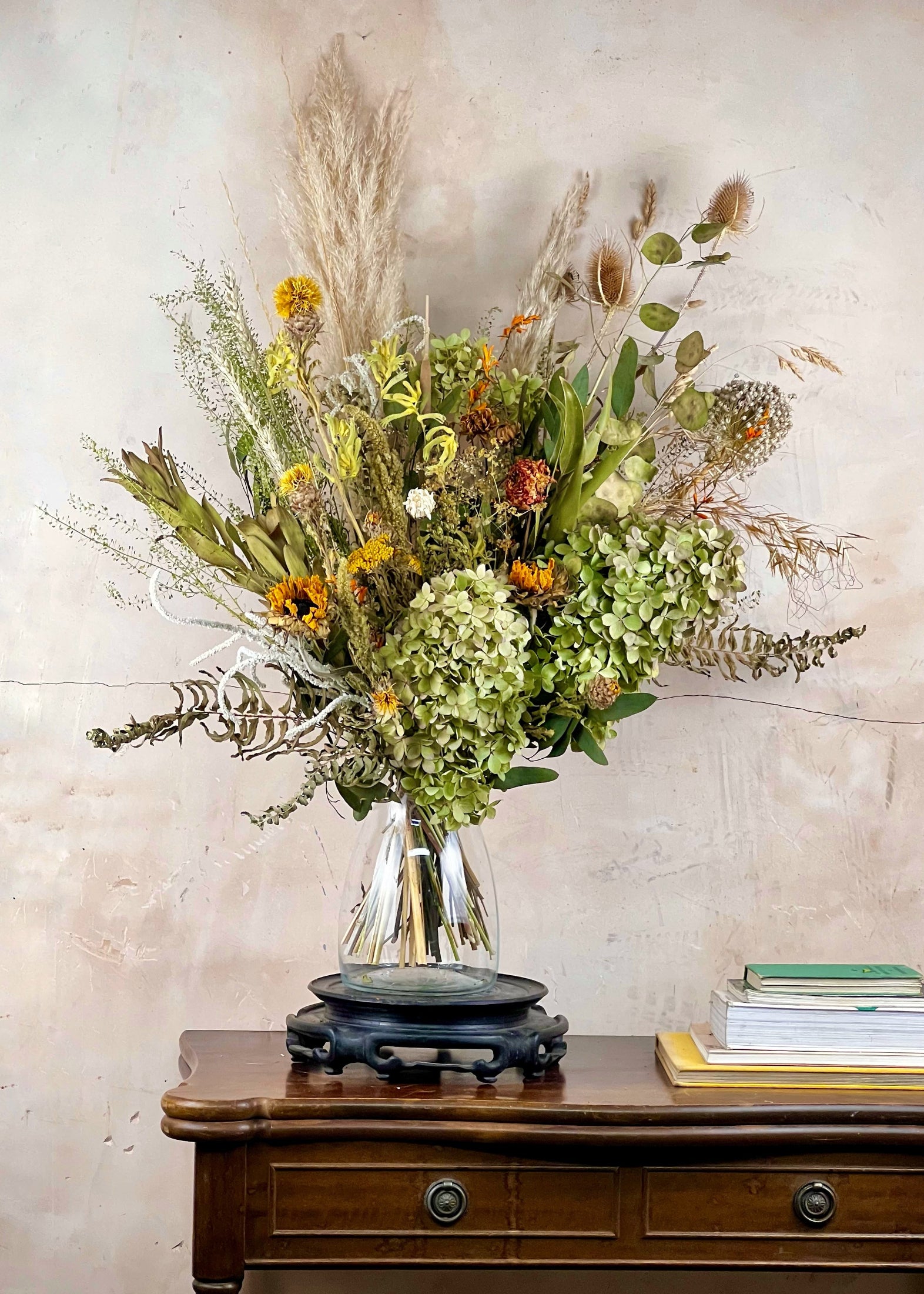 Bouquet of flowers in a clear vase on a wooden table with a neutral background