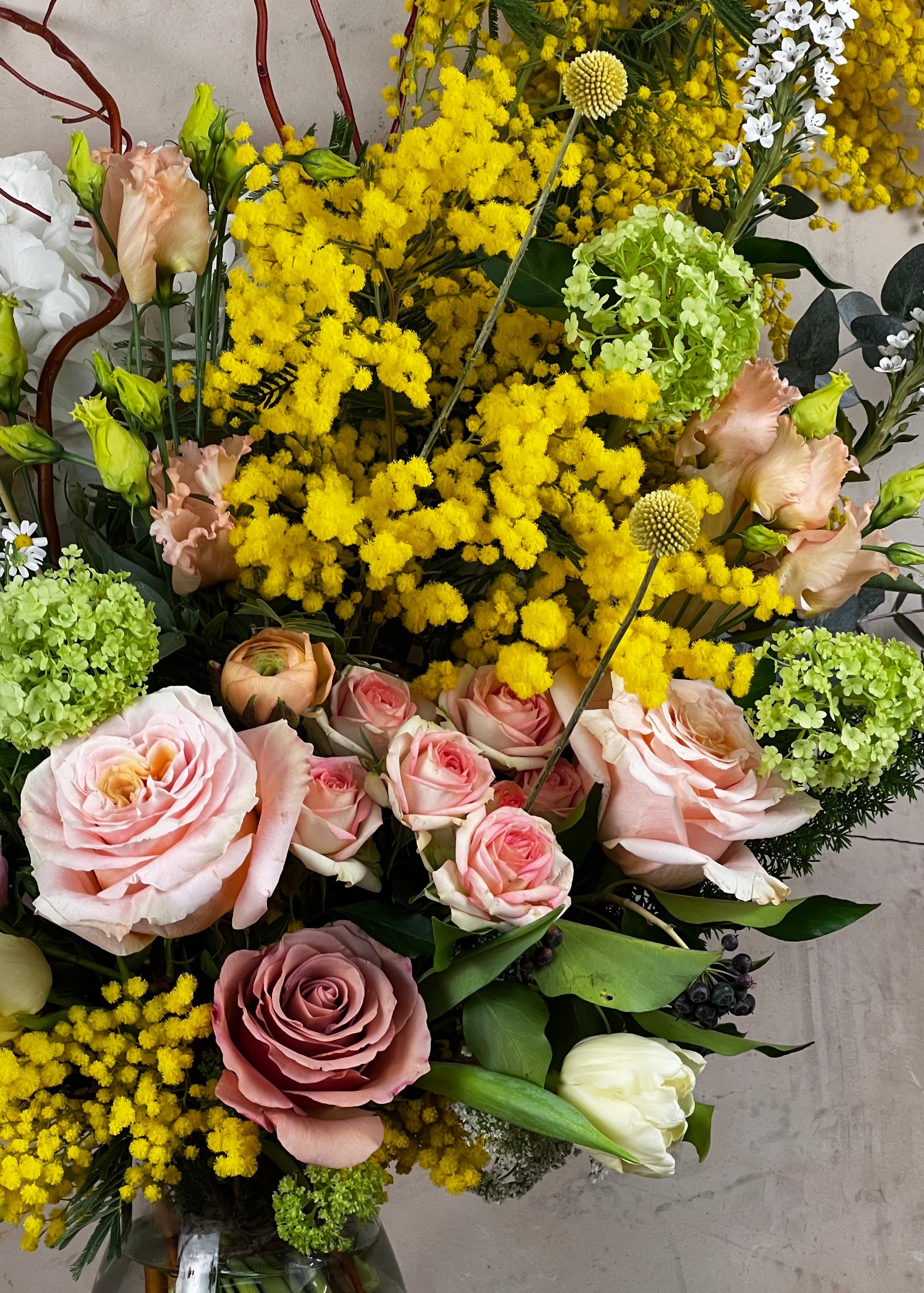 Bouquet of flowers with yellow, pink, and green colors on a neutral background