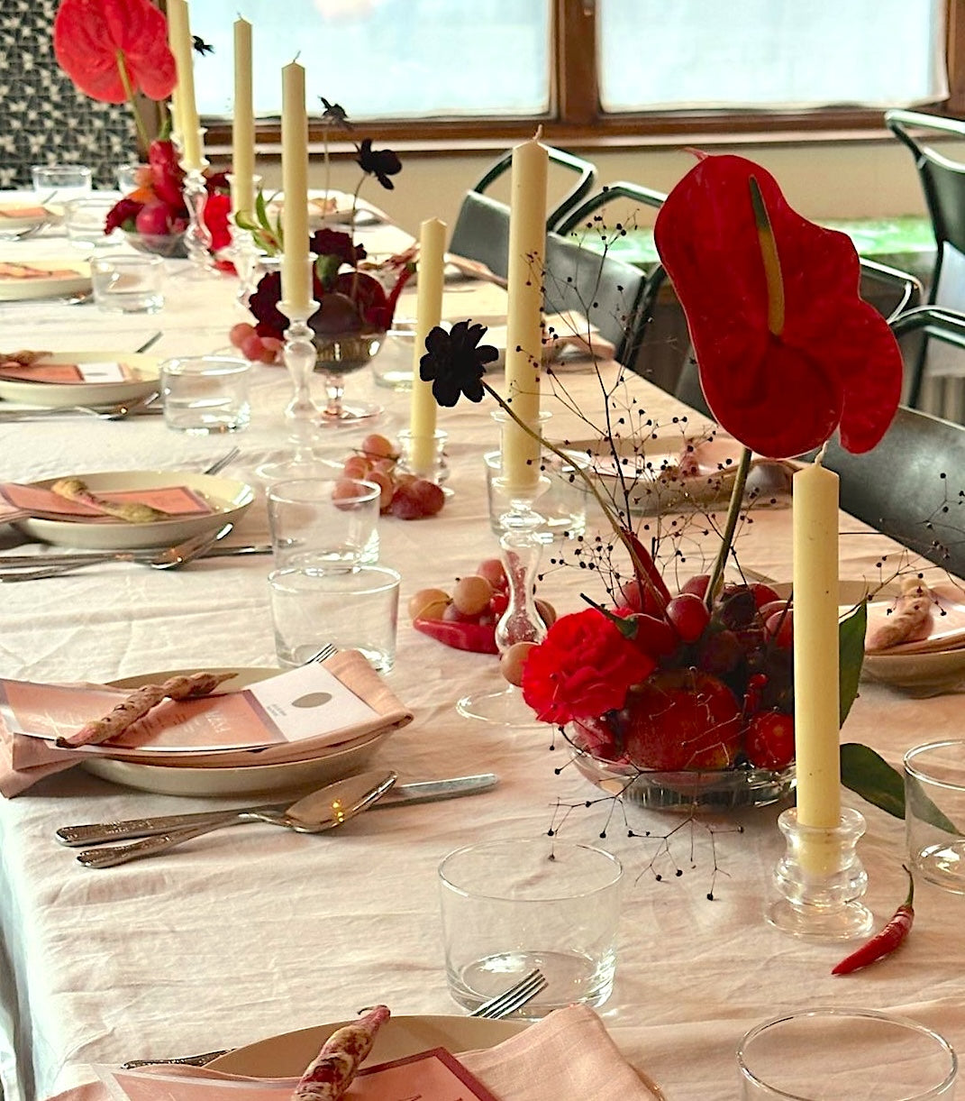 Table floral styling in red and burgundy. Contemporary design with anthurium, carnation and fruit