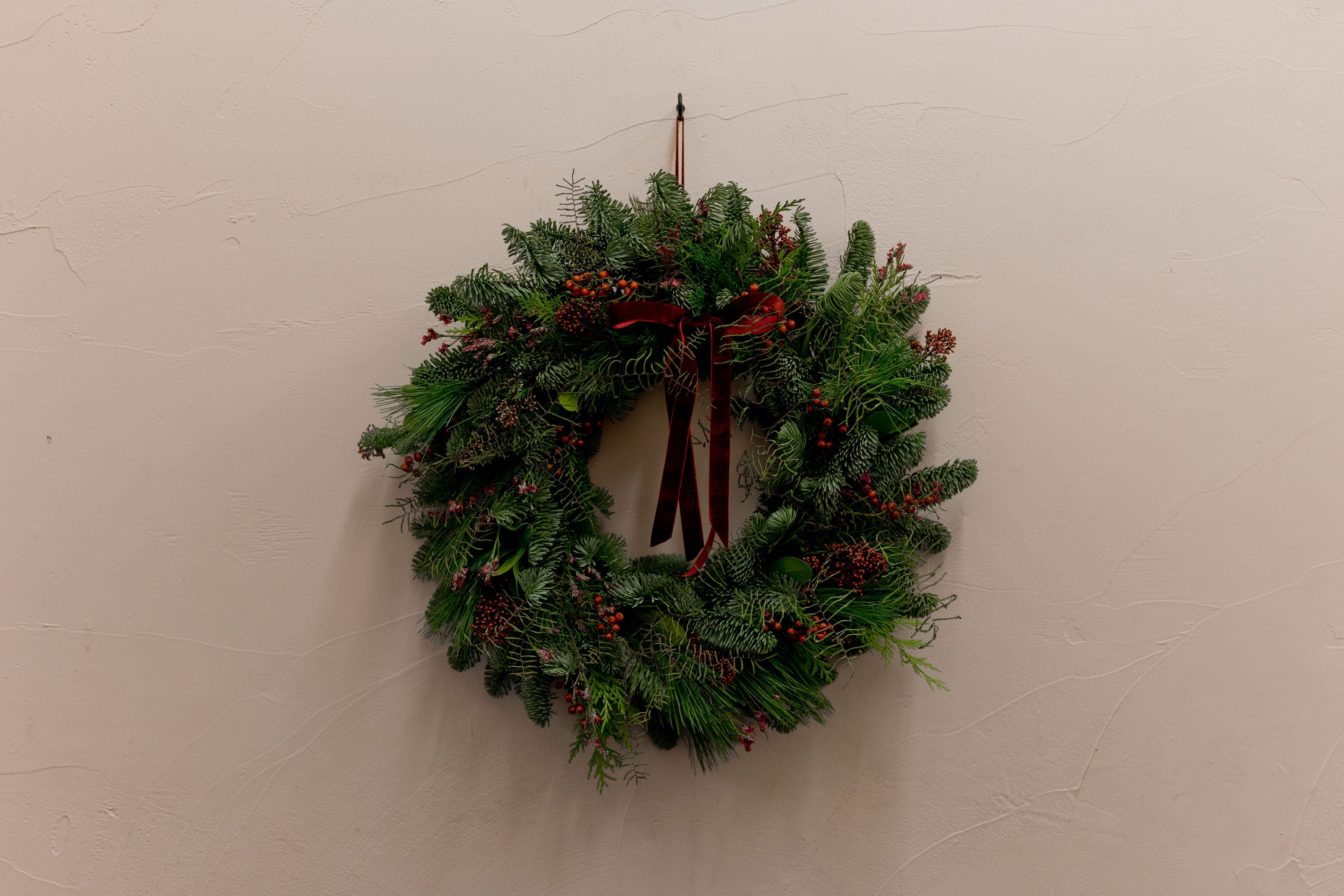 Fresh foliage wreath with winter berries on a wall