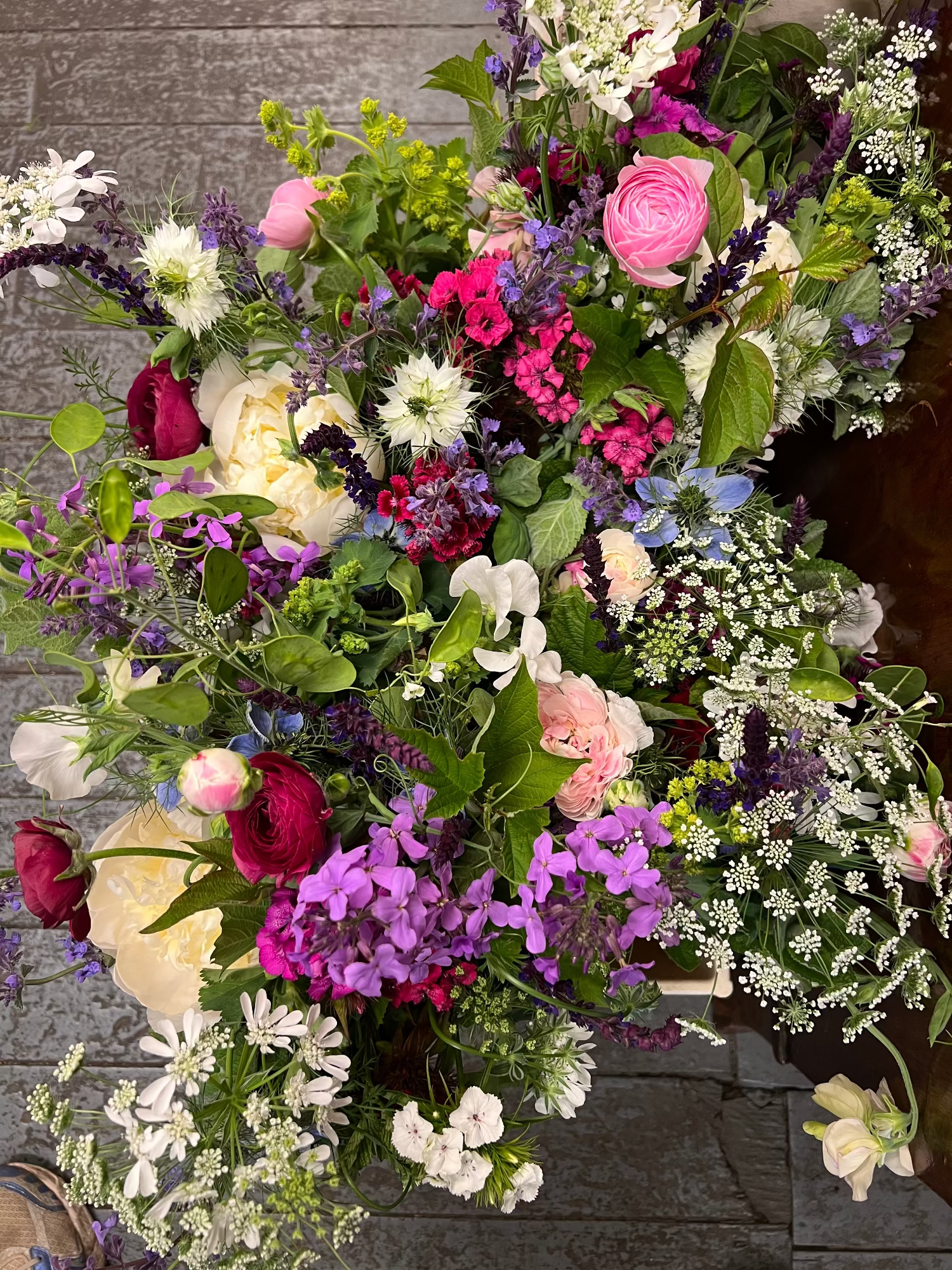 Bucketsof colourful flowers on a stone surface