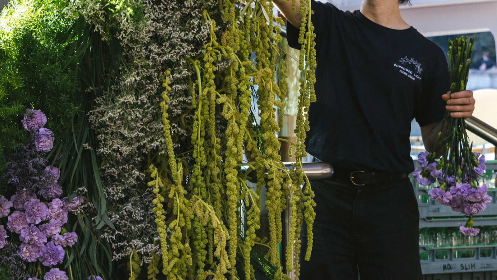 Florist creating large focal installation with flowers of Amaranthus and Carnations