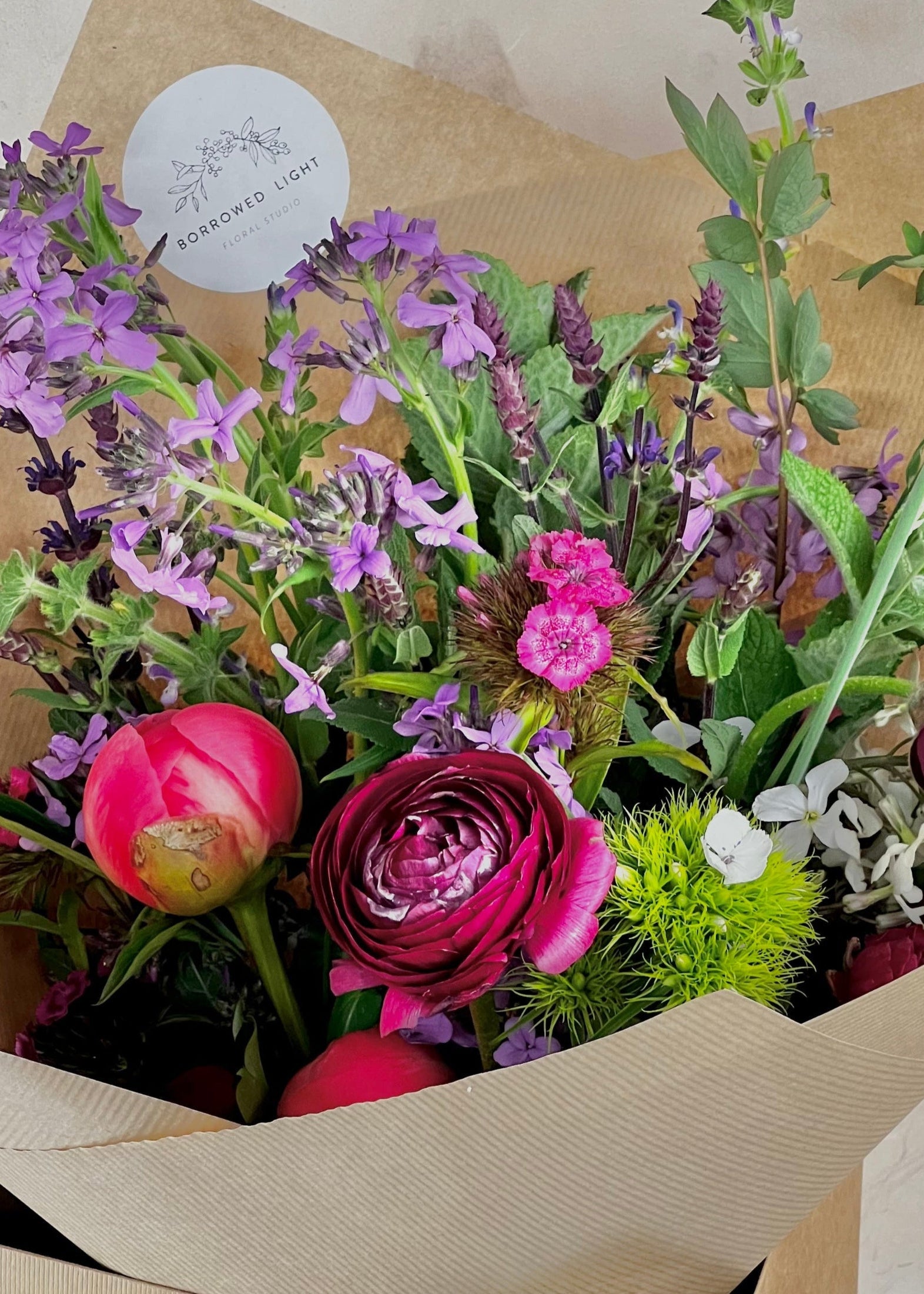 Bouquet of flowers in a box with a visible brand label.