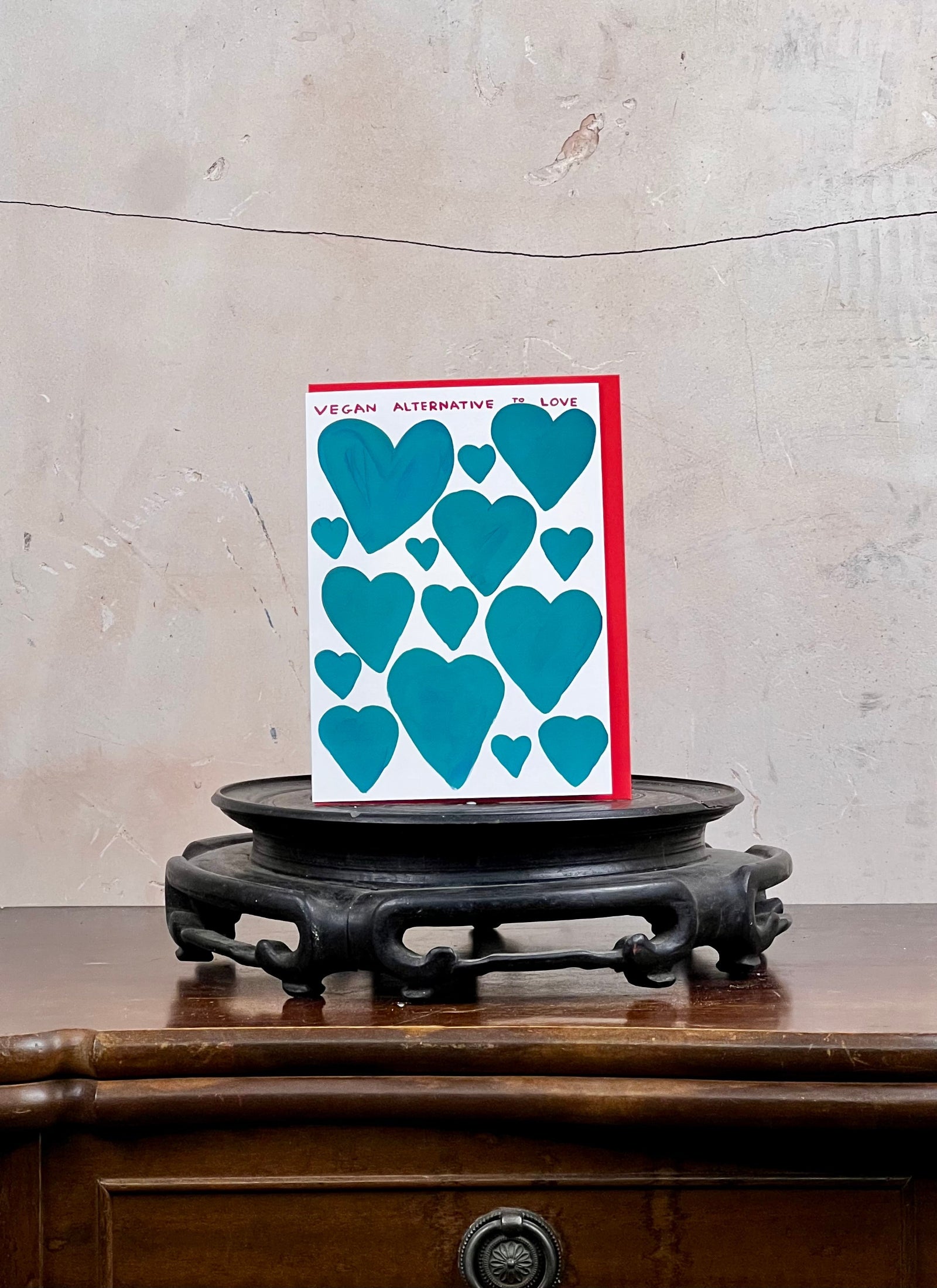 Card with blue heart designs on a wooden surface and gray wall background