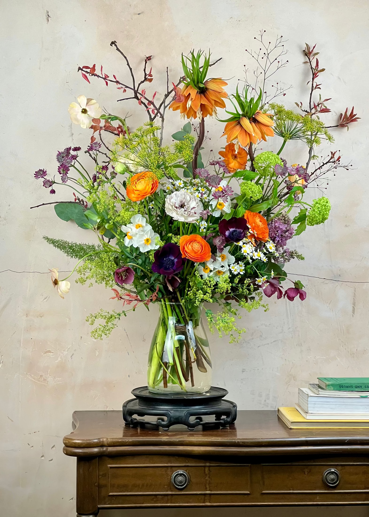 Bouquet of flowers in a glass vase on a wooden table with a neutral background