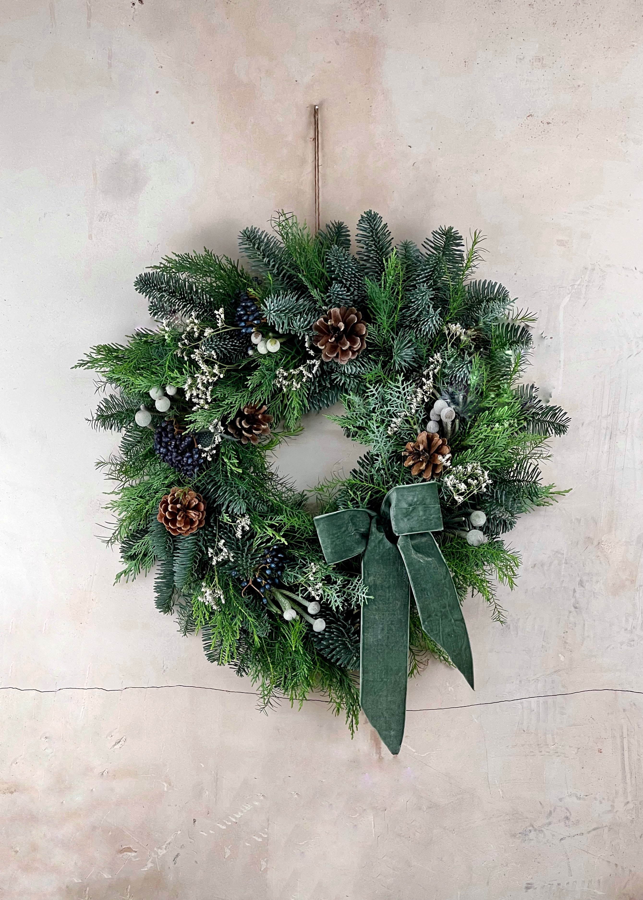 Christmas wreath with green bow on a light background