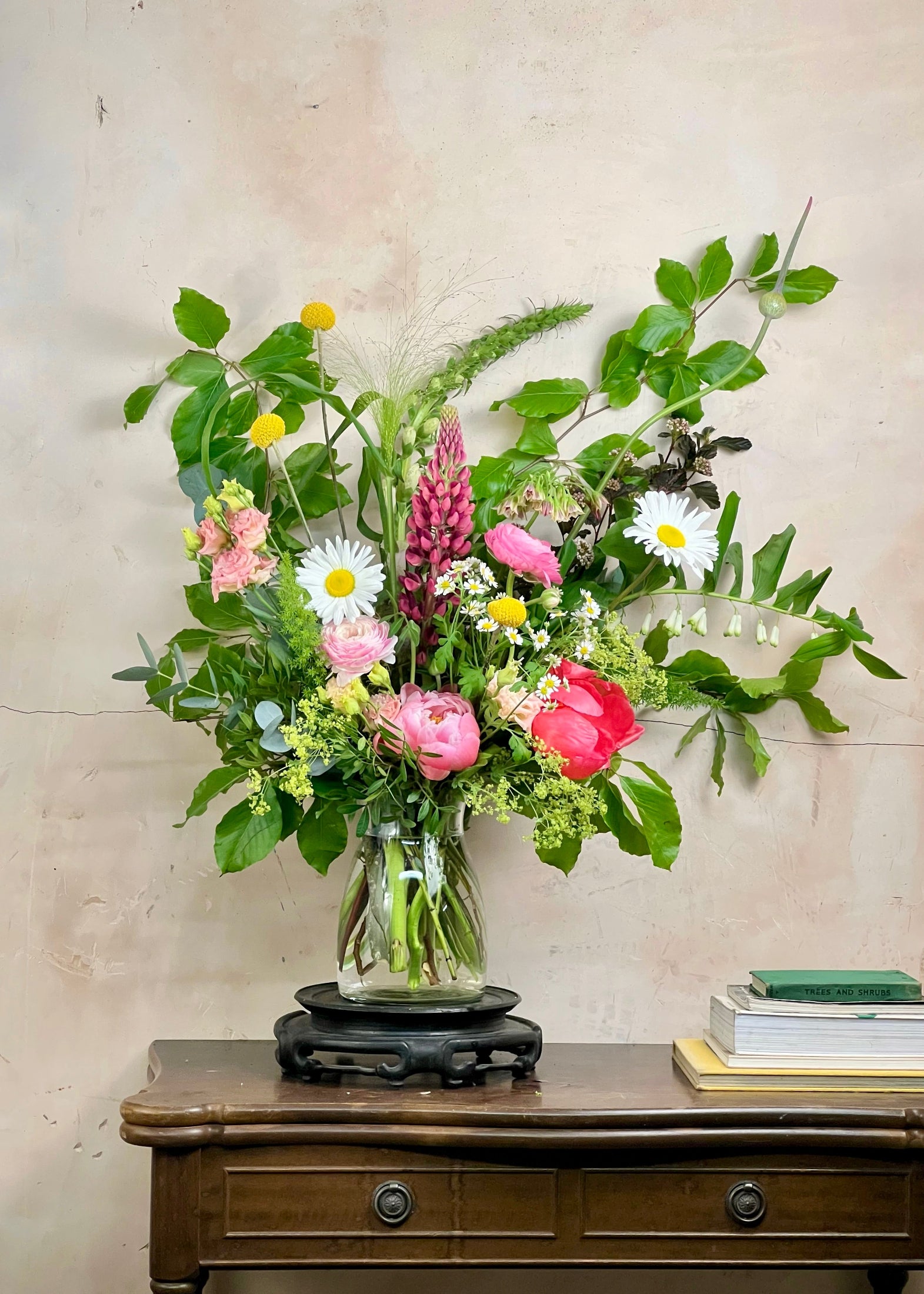 Bouquet of flowers in a vase on a wooden table with a neutral background